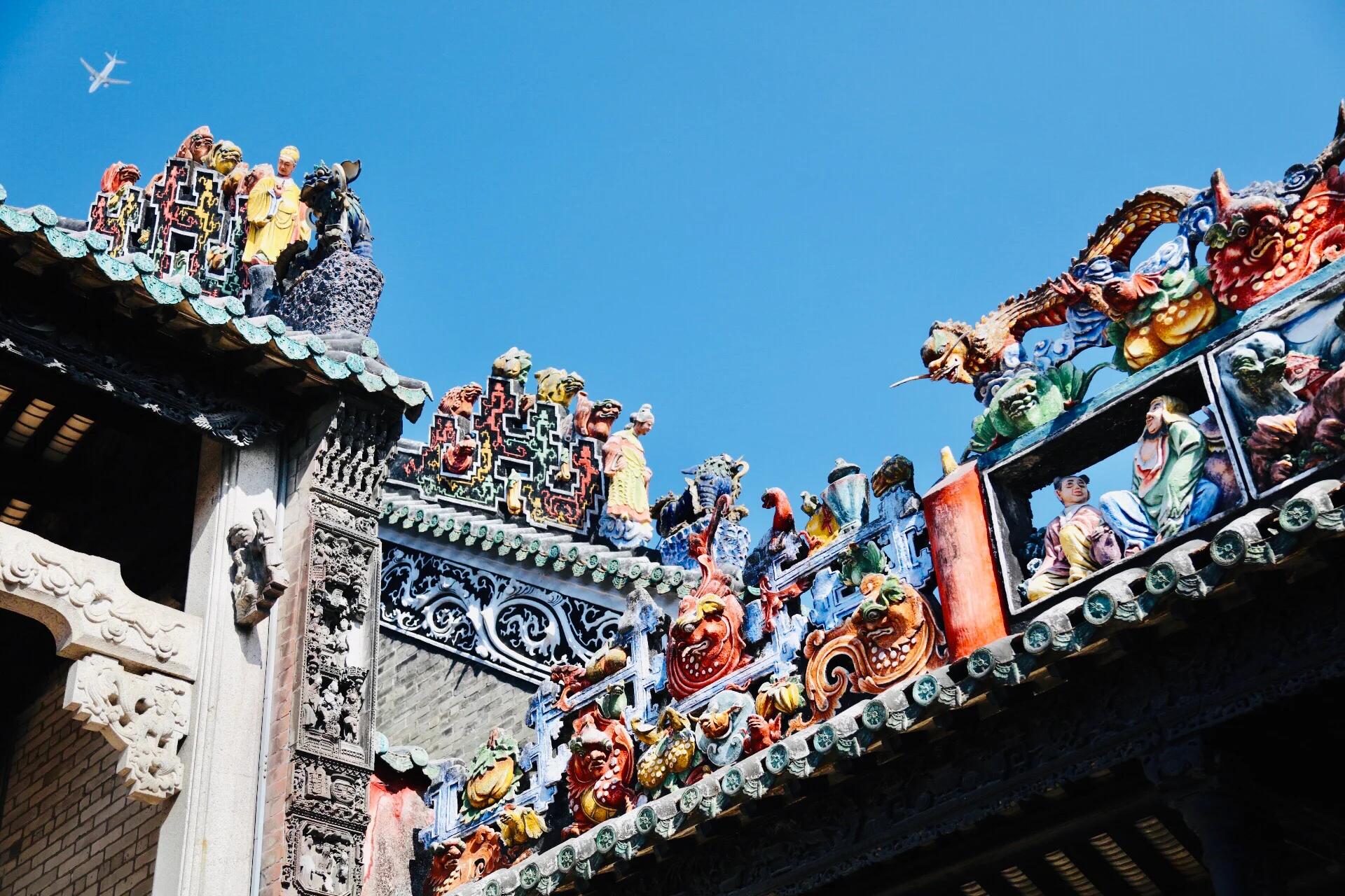 Ornate ceramic roof decorations at Chen Clan Ancestral Hall in Guangzhou showing traditional Cantonese opera figures