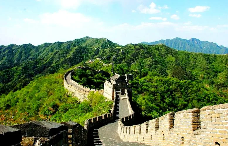 秋季的慕田峪长城，蜿蜒在森林覆盖的山脊上，金黄与红色的树叶相映成辉